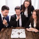 Businesspeople Trying To Solve Maze Puzzle